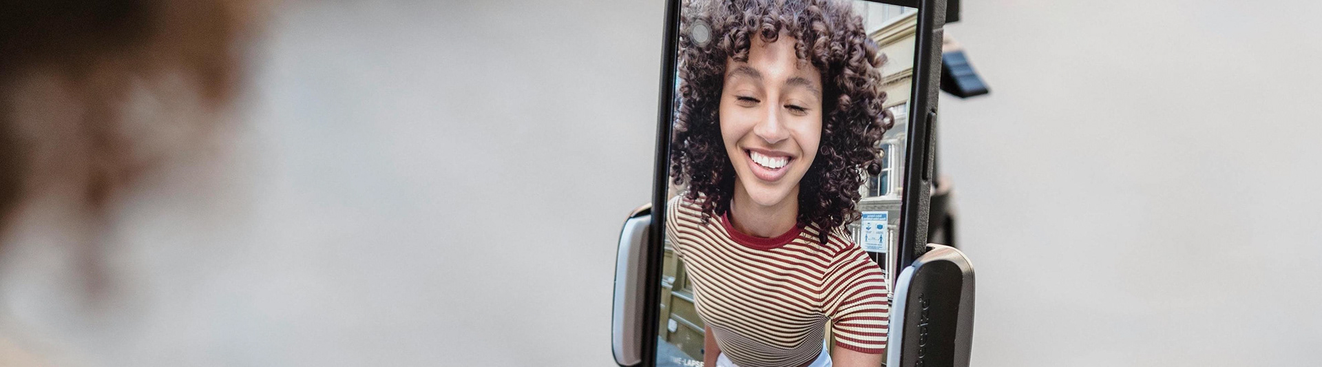 A creator smiling while live-streaming from her phone
